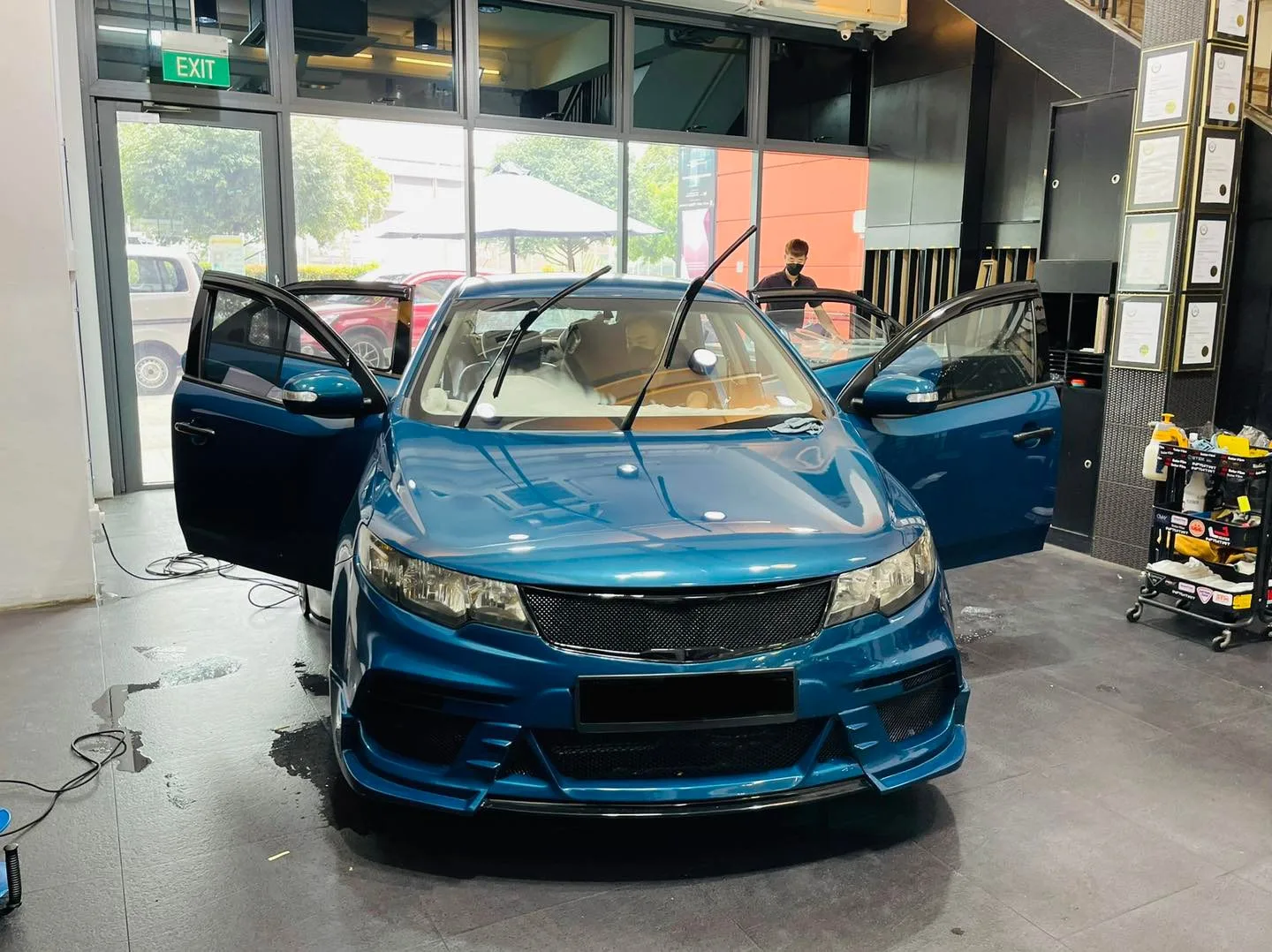 Blue Kia sedan with body kit having windows tinted at Infratint Singapore