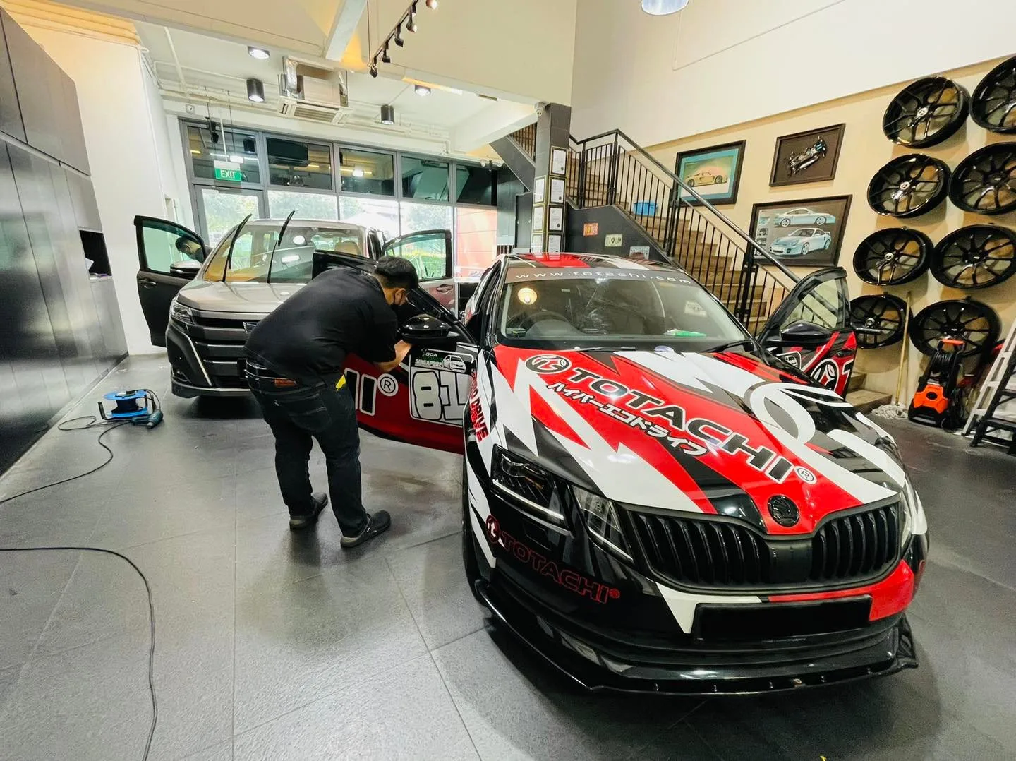 Red and white liveried Skoda sedan being worked on at Infratint Singapore