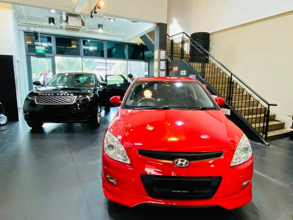 Red Hyundai hatchback and black Range Rover at Infratint Singapore for window tinting