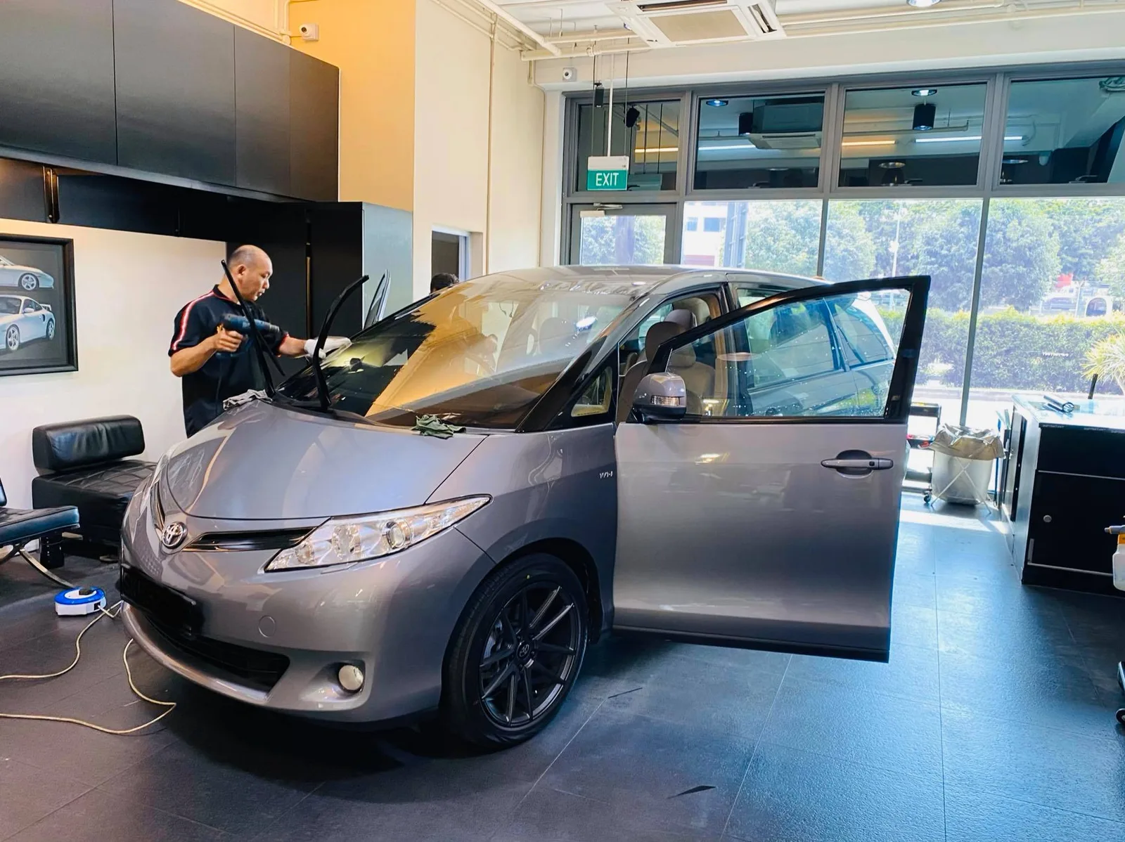 Front three-quarter of a silver Toyota Previa being tinted at Infratint Singapore