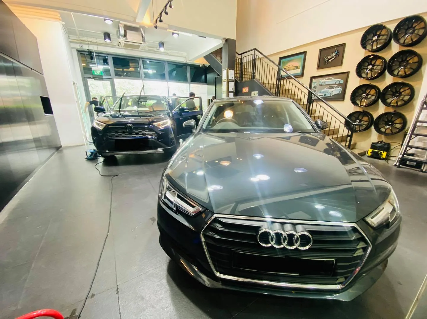 Grey Audi sedan and dark blue Toyota RAV4 inside the Infratint Singapore showroom for tinting