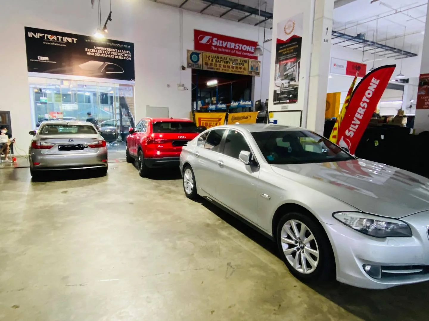 Silver BMW sedan, red Audi SUV and silver Lexus in the Infratint Singapore workshop