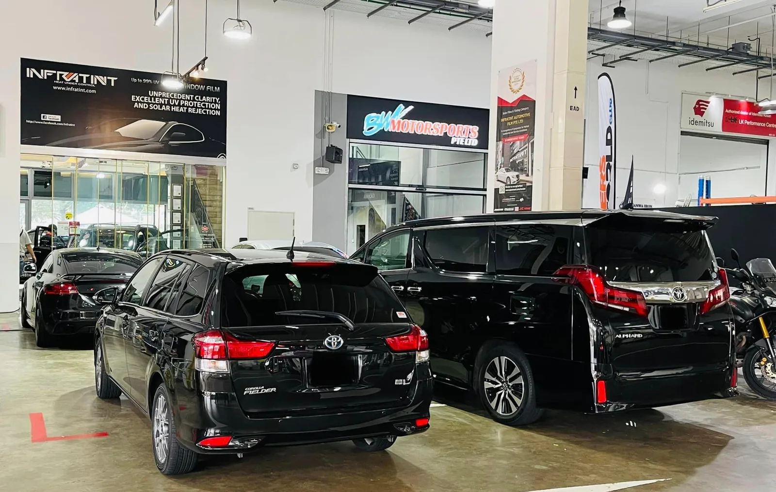Black Toyota wagon and Alphard MPV in the install bay at Infratint Singapore