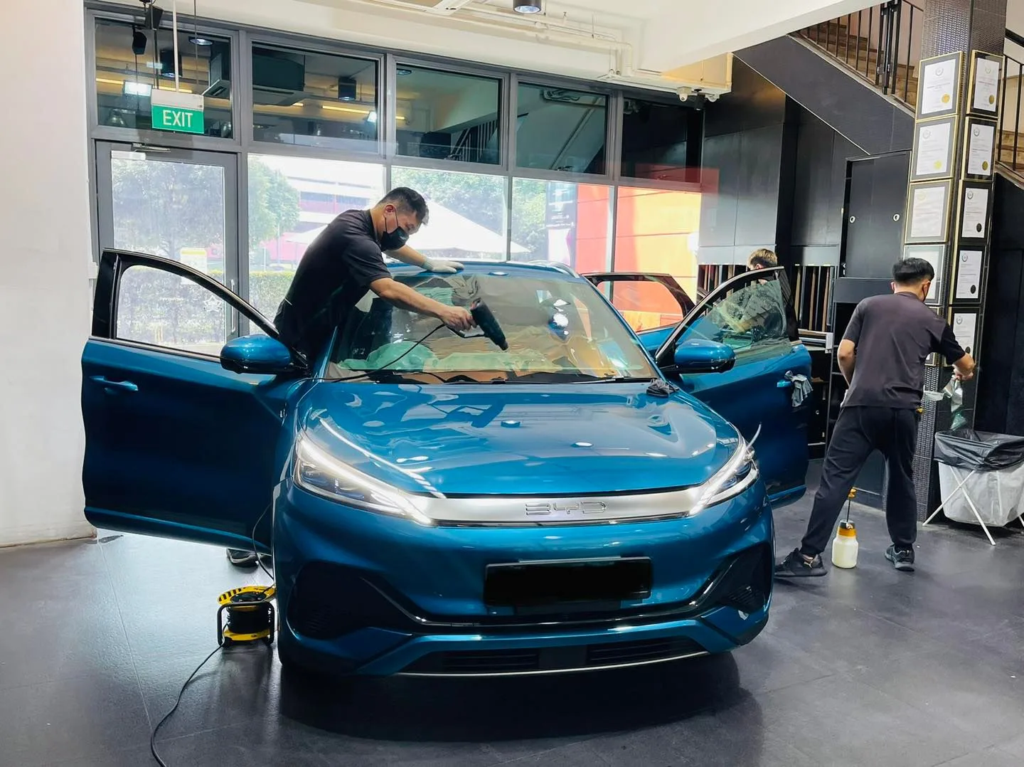 Blue BYD Atto 3 front view with doors open during window tinting at Infratint Singapore