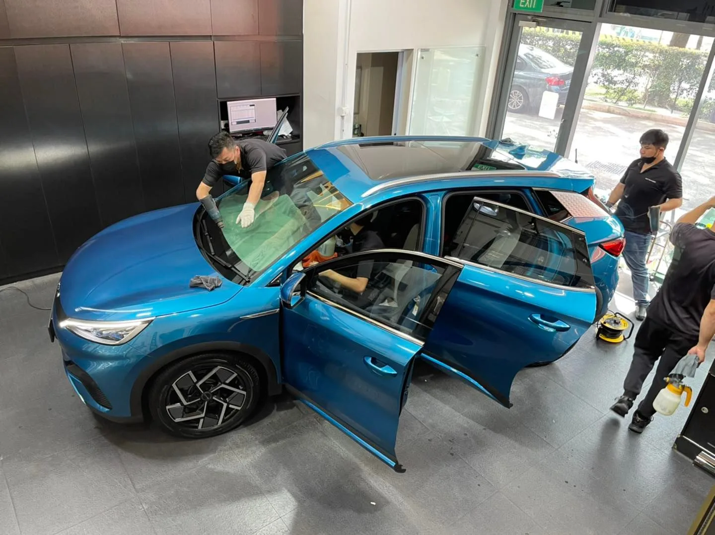 Overhead view of a blue BYD Atto 3 being tinted at Infratint Singapore