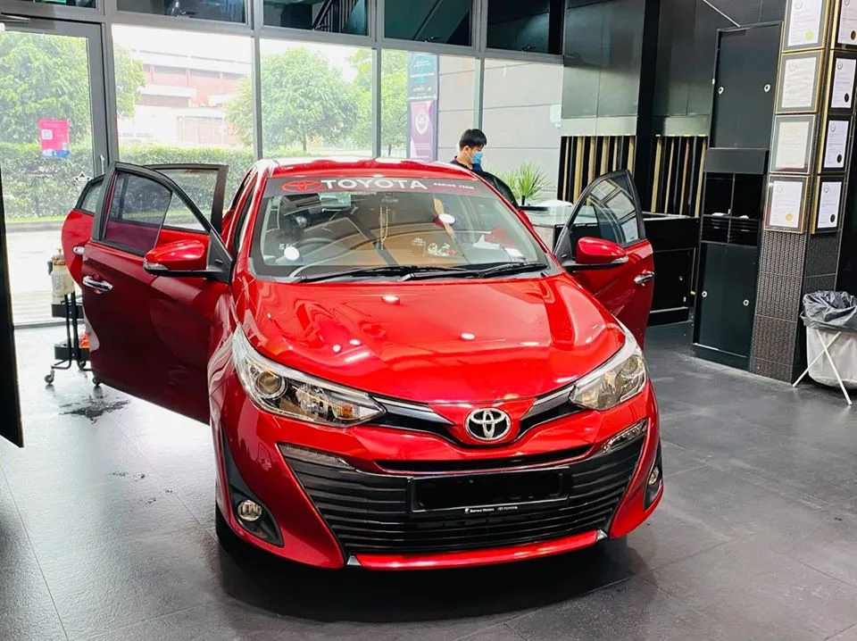Red Toyota sedan with doors open during window tinting at Infratint Singapore