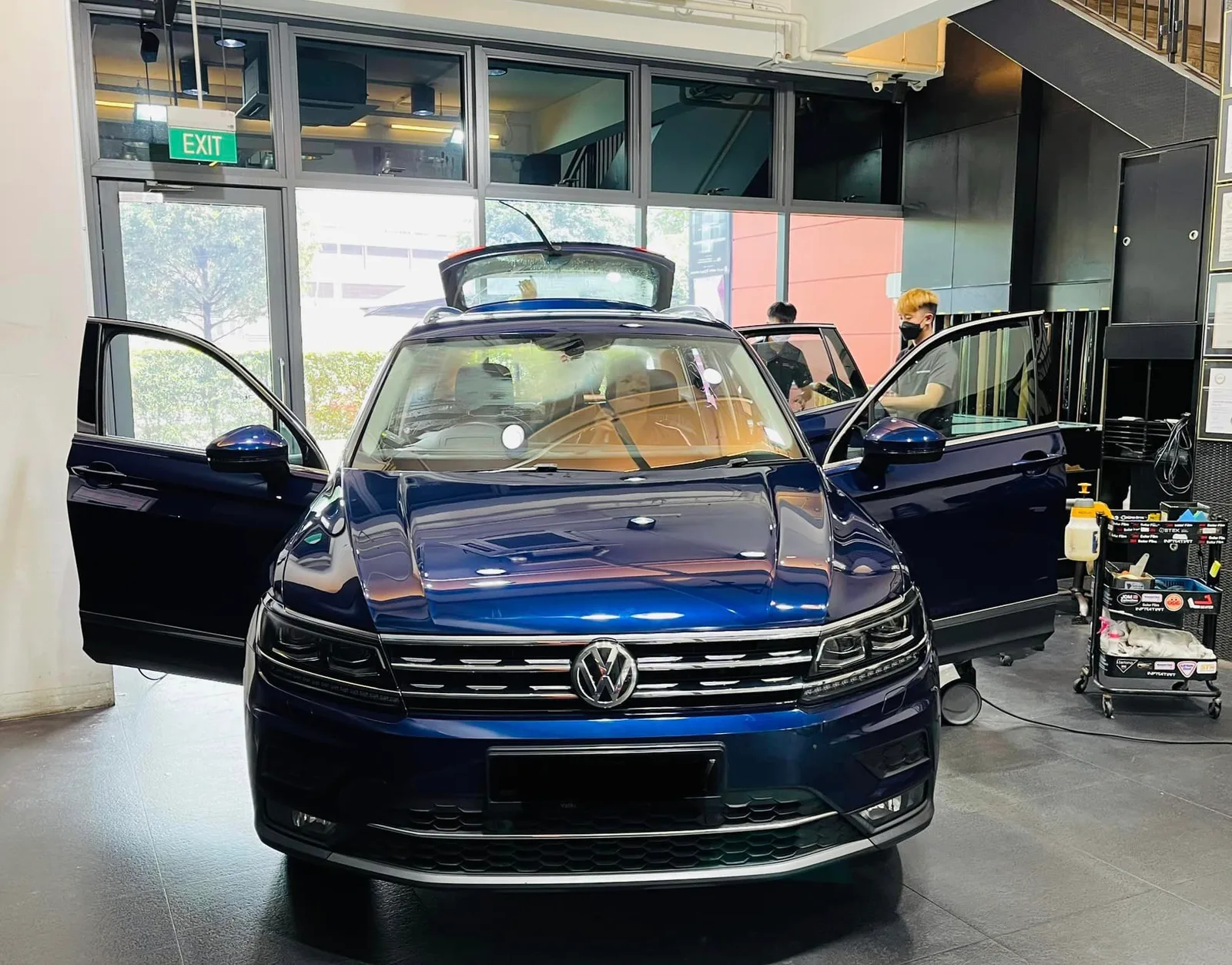 Dark blue Volkswagen Tiguan with doors open at Infratint Singapore for window tinting