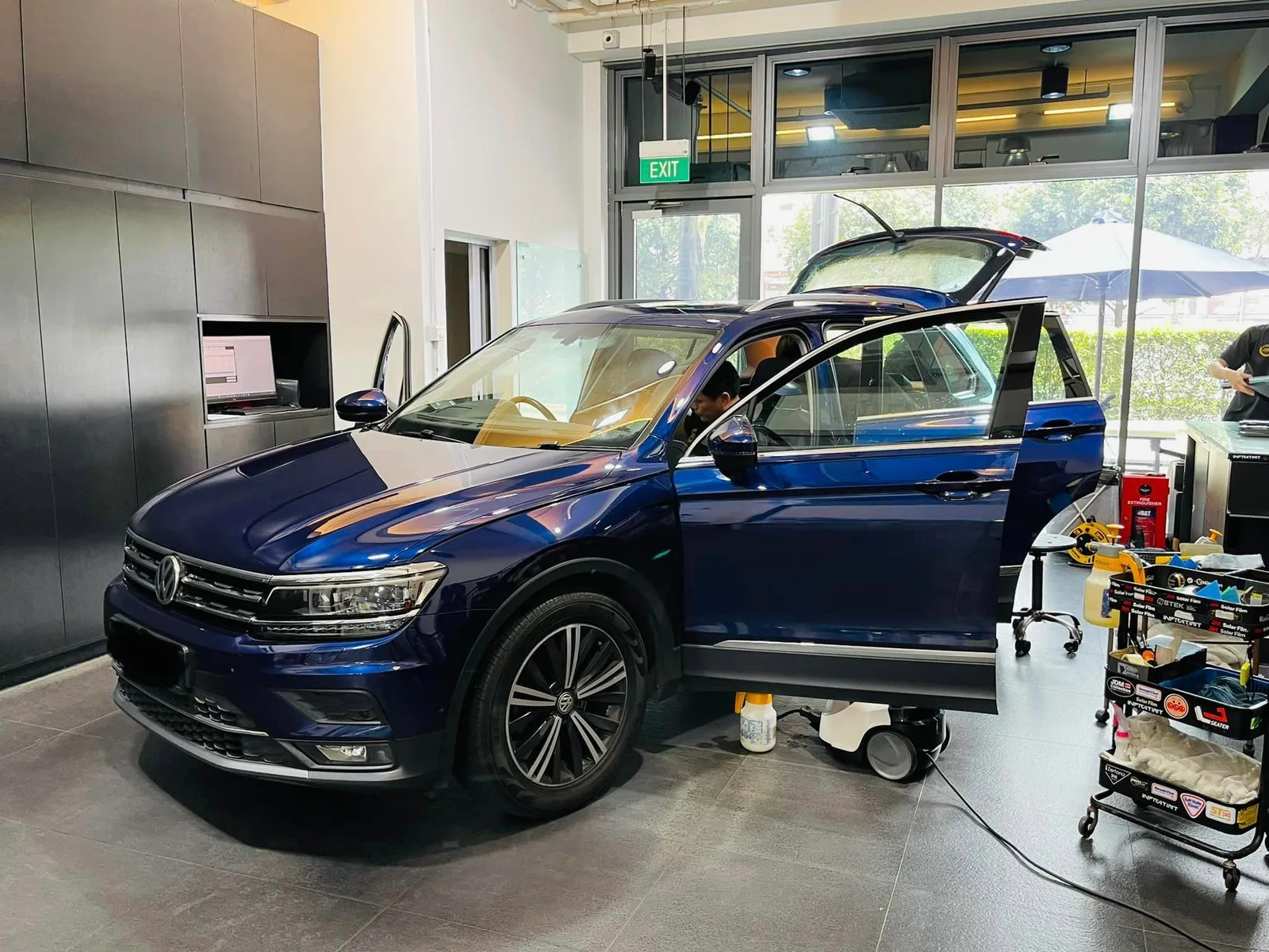 Dark blue Volkswagen Tiguan with tailgate up during window film install at Infratint Singapore