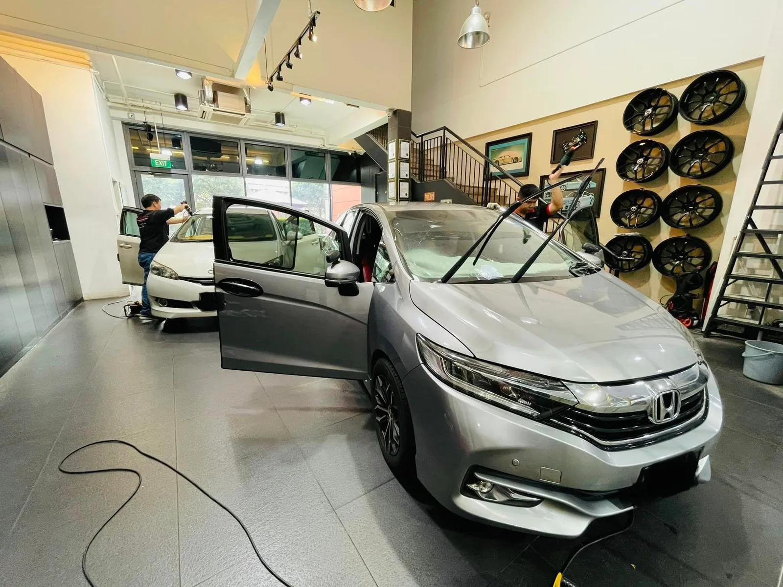 Silver Honda Shuttle in three-quarter view at Infratint Singapore beside a wheel display