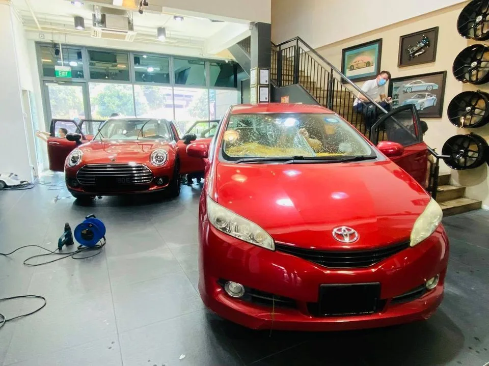 Red Toyota Wish MPV and red Mini Cooper inside Infratint Singapore showroom