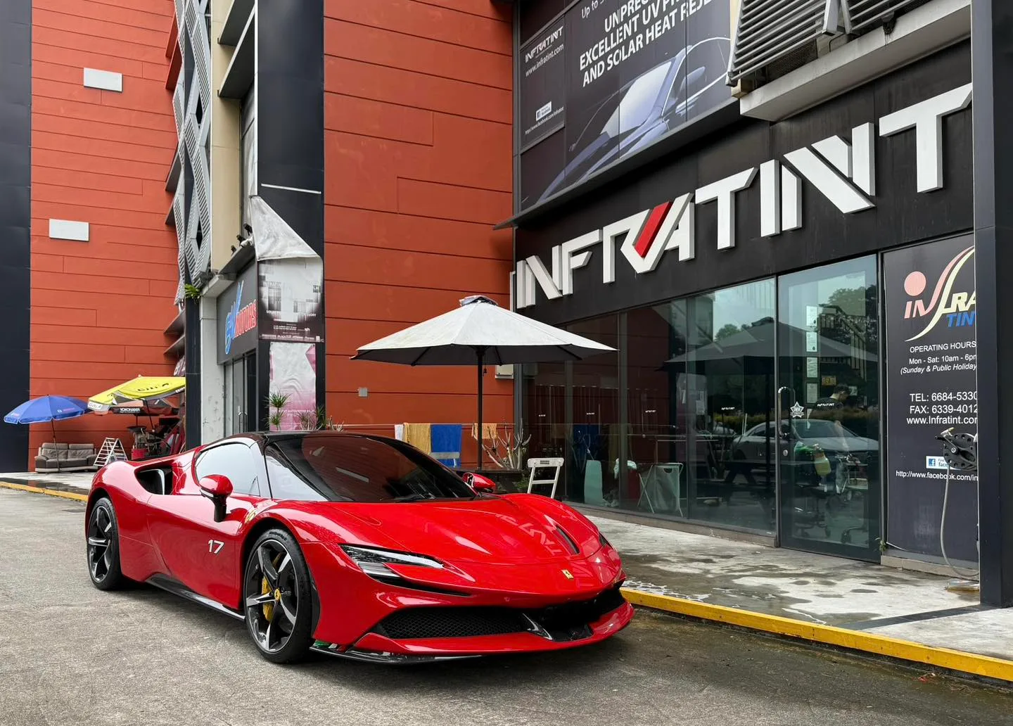 Red Ferrari SF90 front three-quarter view outside Infratint Singapore
