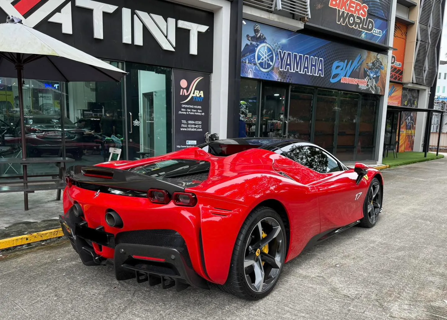 Red Ferrari SF90 side profile outside Infratint Singapore