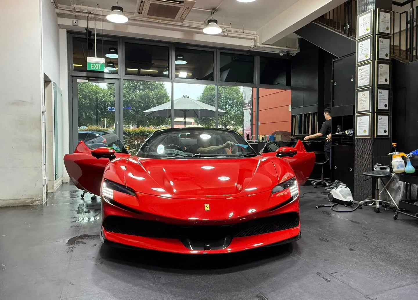 Technician installing window film on a Ferrari SF90 inside the Infratint workshop