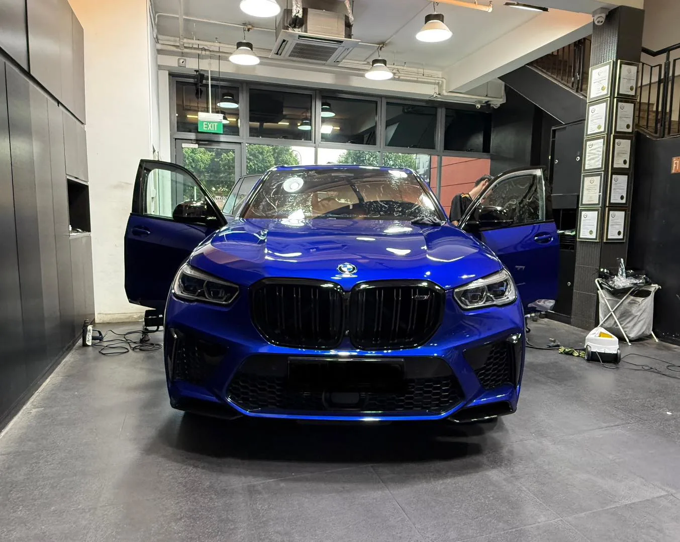 Blue BMW X5 M with doors open in the install bay at Infratint Singapore