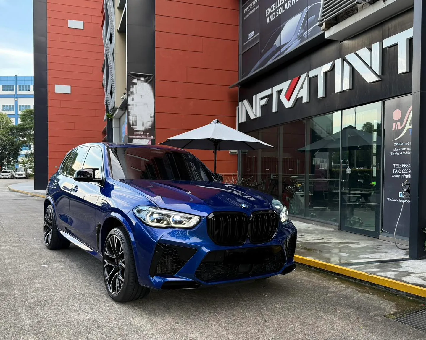 Blue BMW X5 M SUV parked outside the Infratint Singapore shopfront