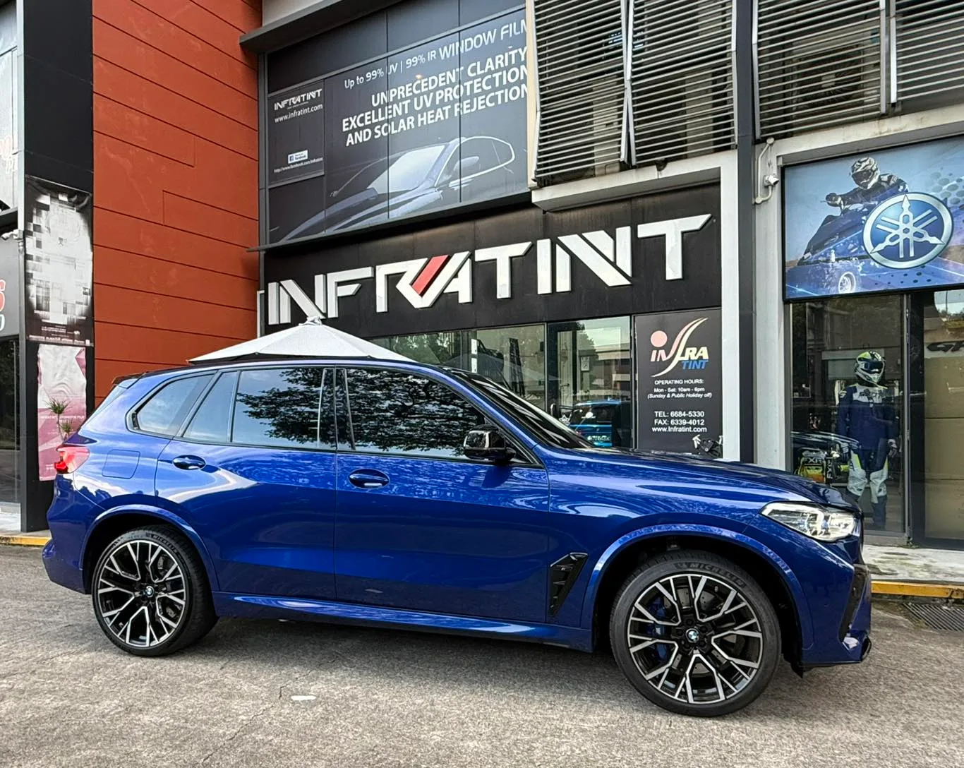 Blue BMW X5 M in side profile outside Infratint Singapore