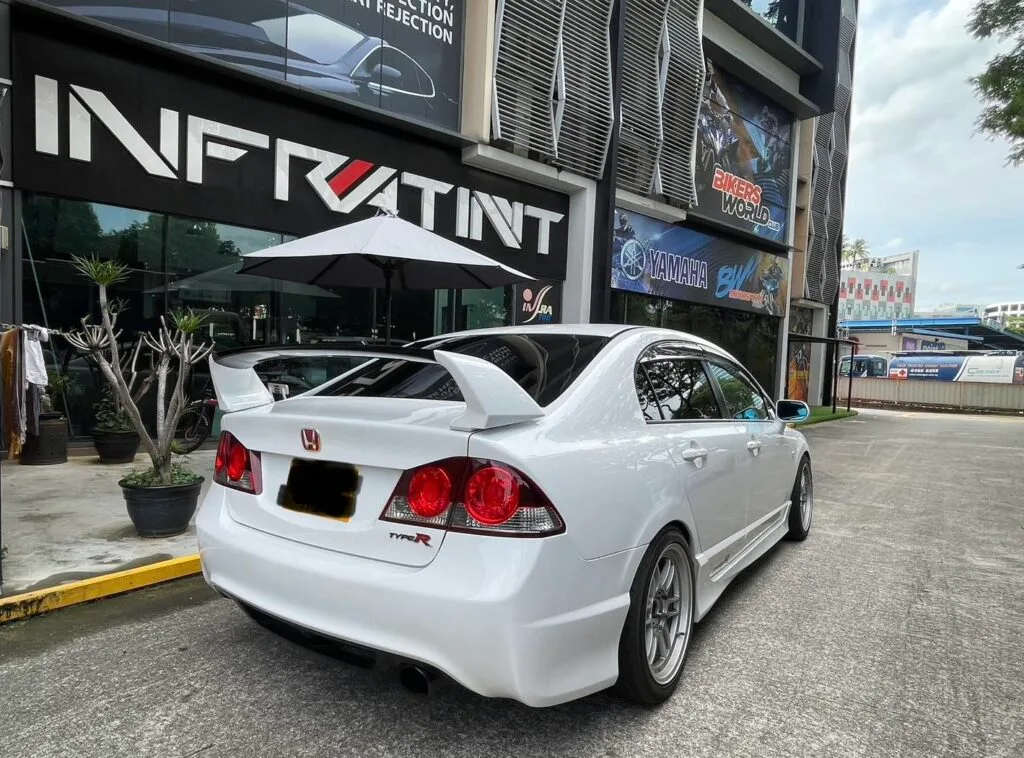 White Honda Civic Type R rear three-quarter view with rear wing outside Infratint Singapore