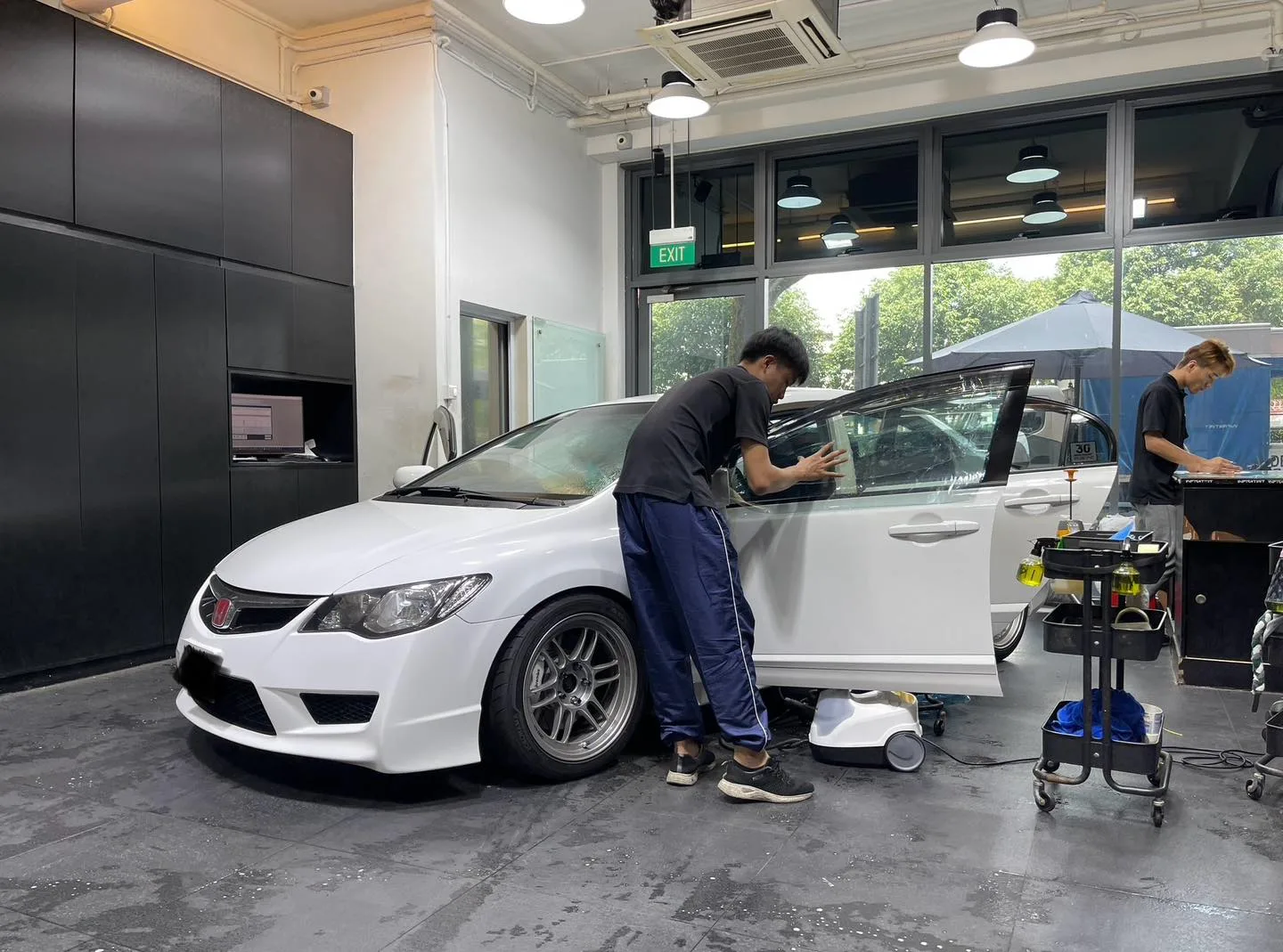 Installers fitting window film to a white Honda Civic Type R at Infratint workshop