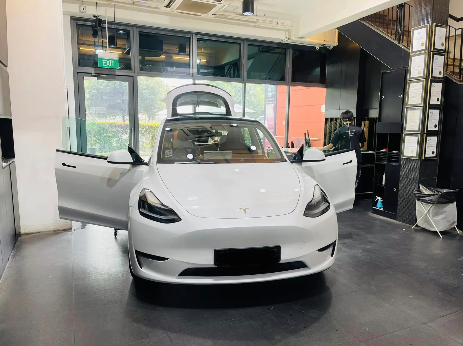 White Tesla Model Y with doors open during window tinting at Infratint Singapore