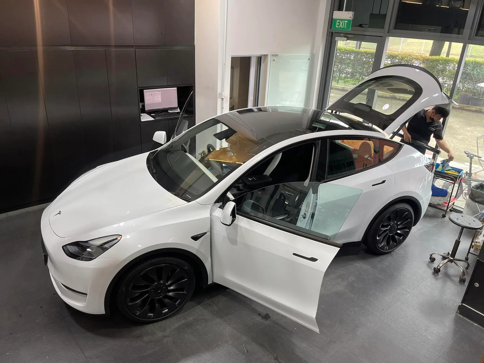 Overhead view of a white Tesla Model Y during window film installation at Infratint Singapore