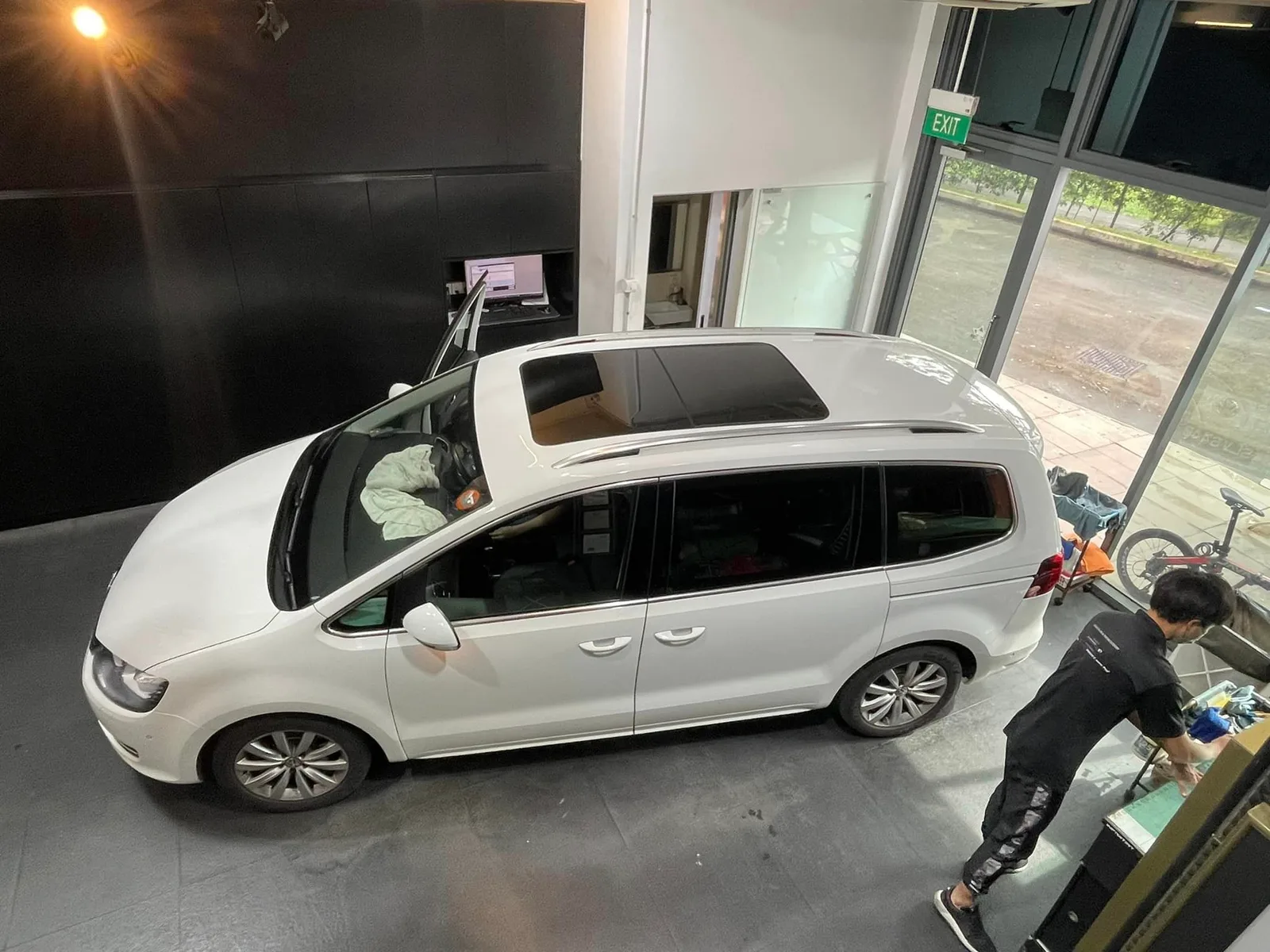 Overhead view of a white Volkswagen Sharan with panoramic roof during tinting at Infratint Singapore