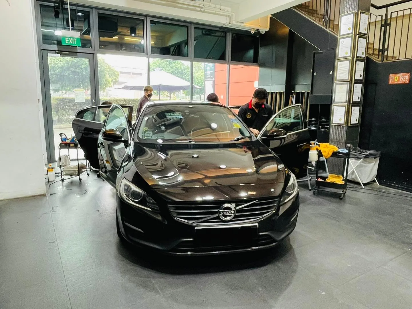 Black Volvo S60 with doors open during window tinting at Infratint Singapore