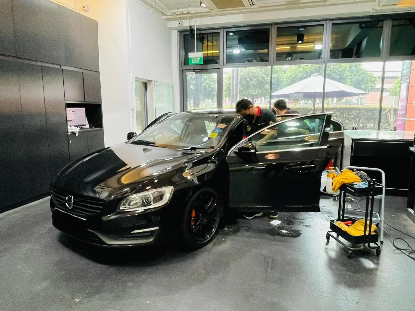 Installers tinting a black Volvo S60 at Infratint Singapore