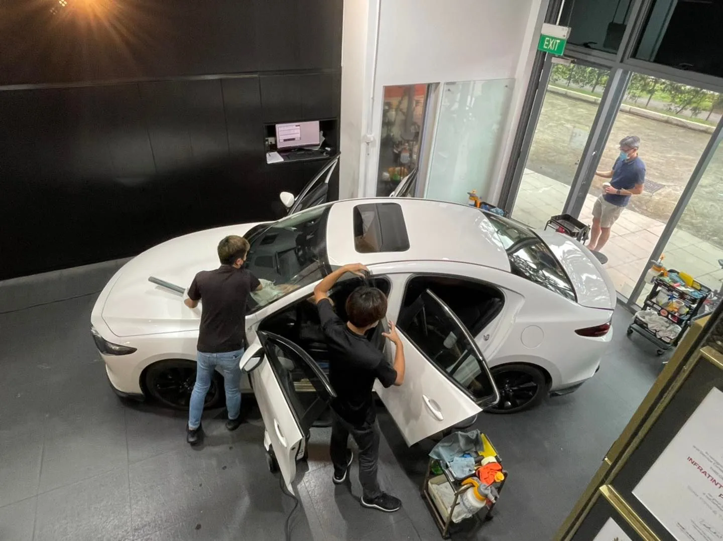Overhead view of a white Mazda 3 sedan being tinted at Infratint Singapore