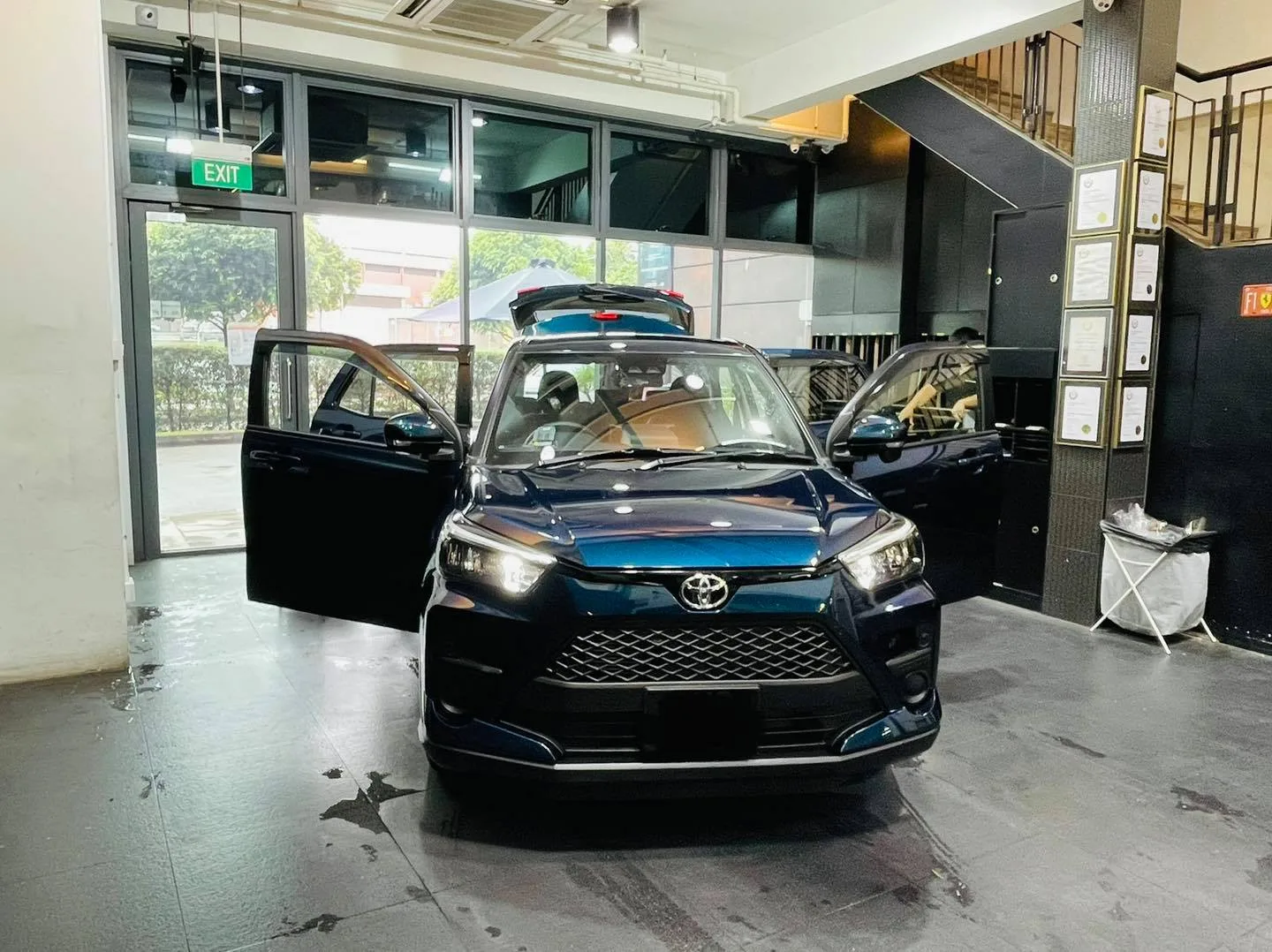 Dark blue Toyota Raize with doors open during window tinting at Infratint Singapore