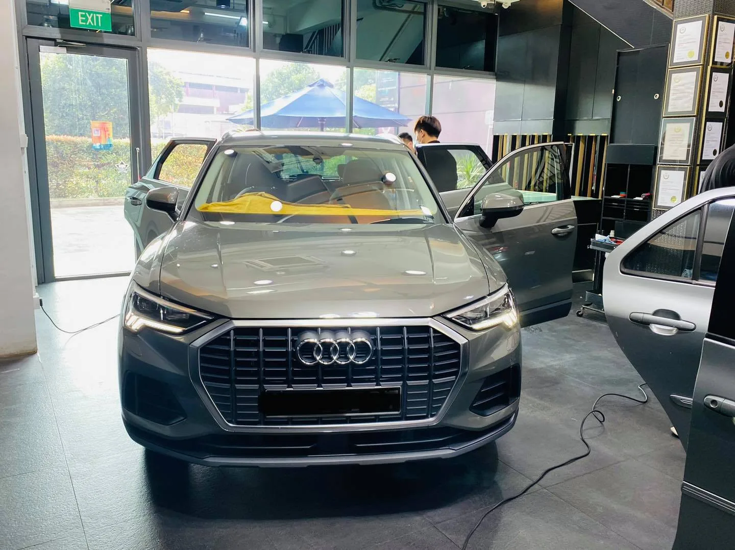 Grey Audi Q3 with doors open during window tinting at Infratint Singapore