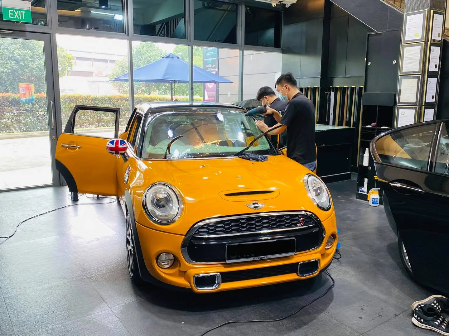 Orange Mini Cooper with Union Jack roof during window tinting at Infratint Singapore