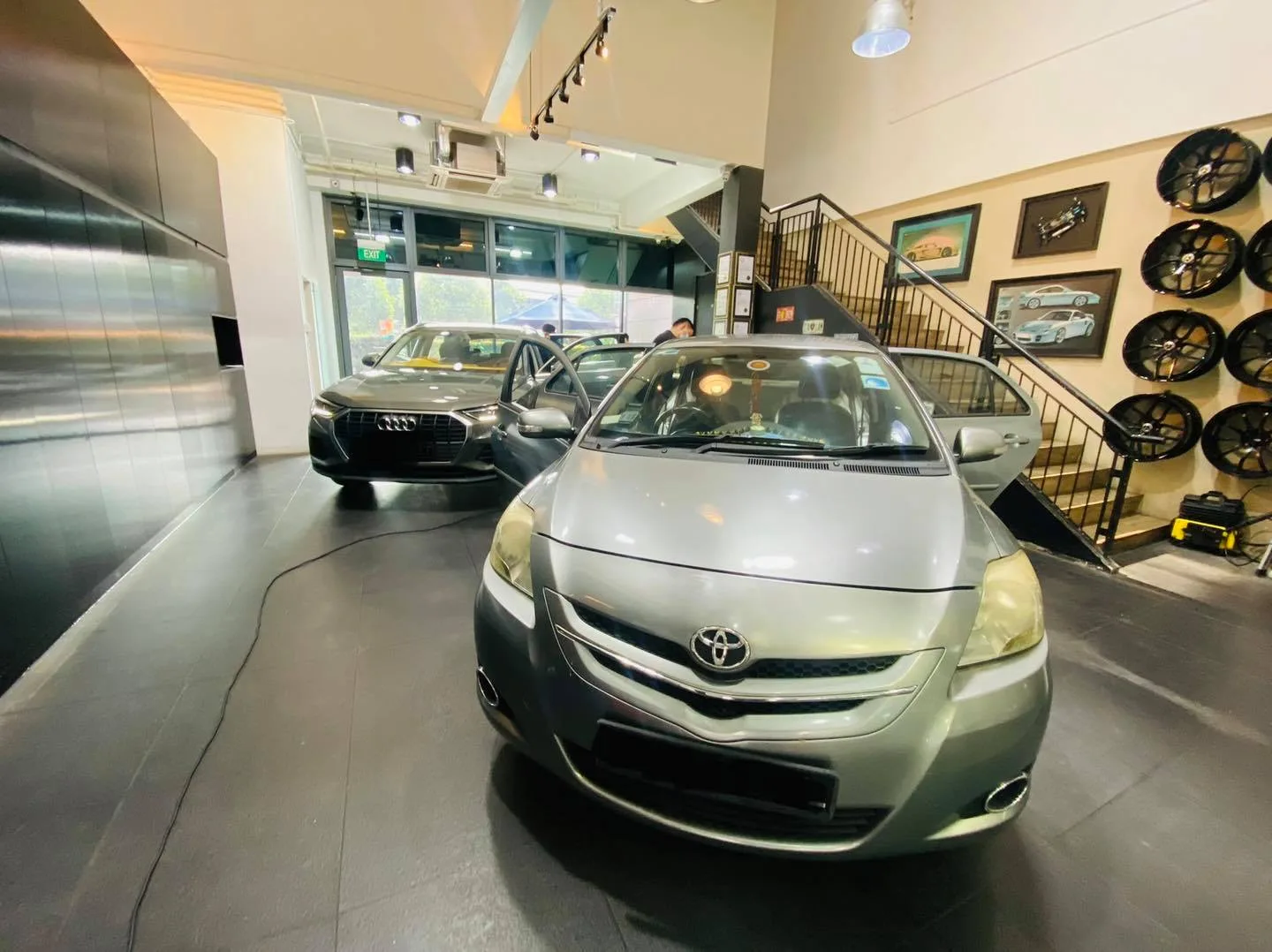Silver Toyota sedan and grey Audi Q3 inside the Infratint Singapore showroom for window tinting