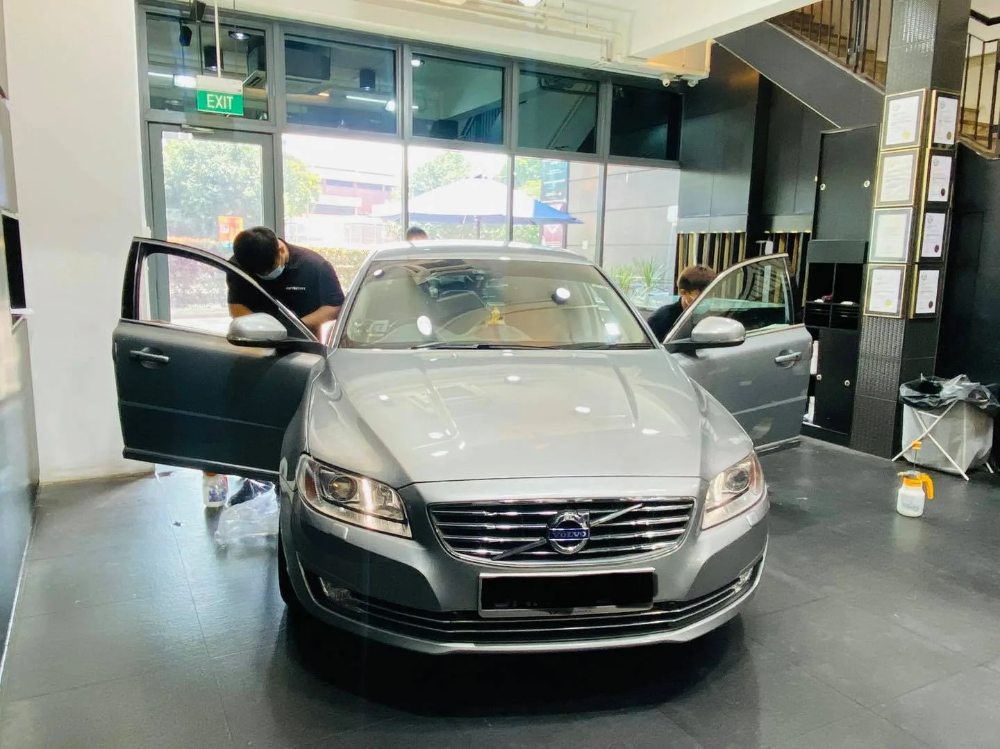 Silver Volvo sedan with doors open during window film install at Infratint Singapore