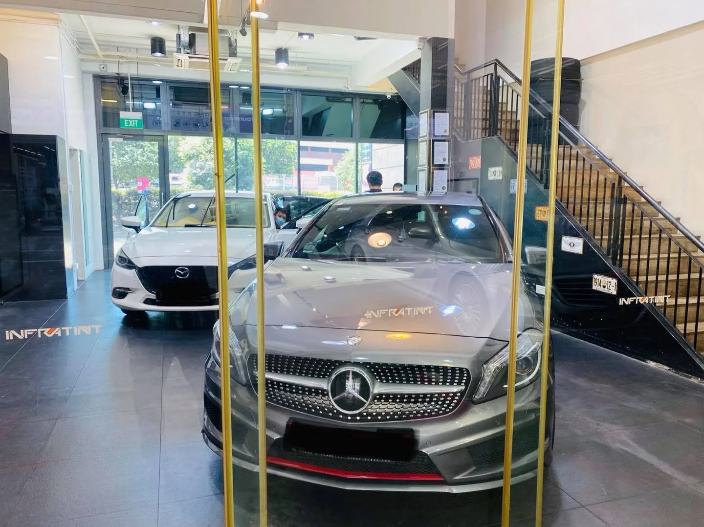 Grey Mercedes-Benz A-Class and white Mazda 3 in the Infratint Singapore showroom