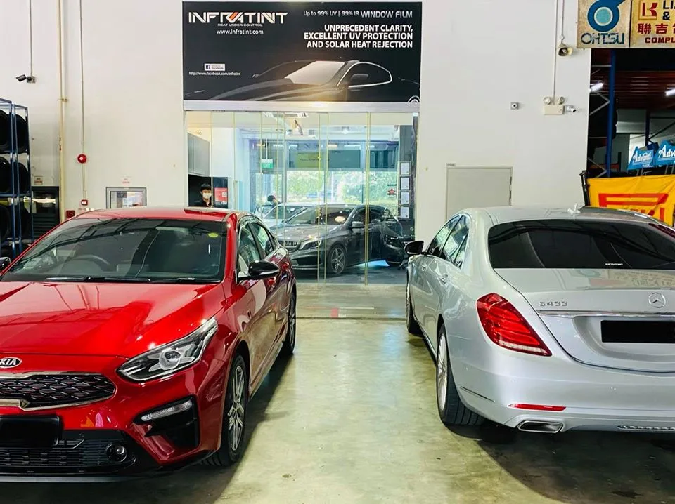 Red Kia sedan and silver Mercedes-Benz S-Class under the Infratint Singapore banner