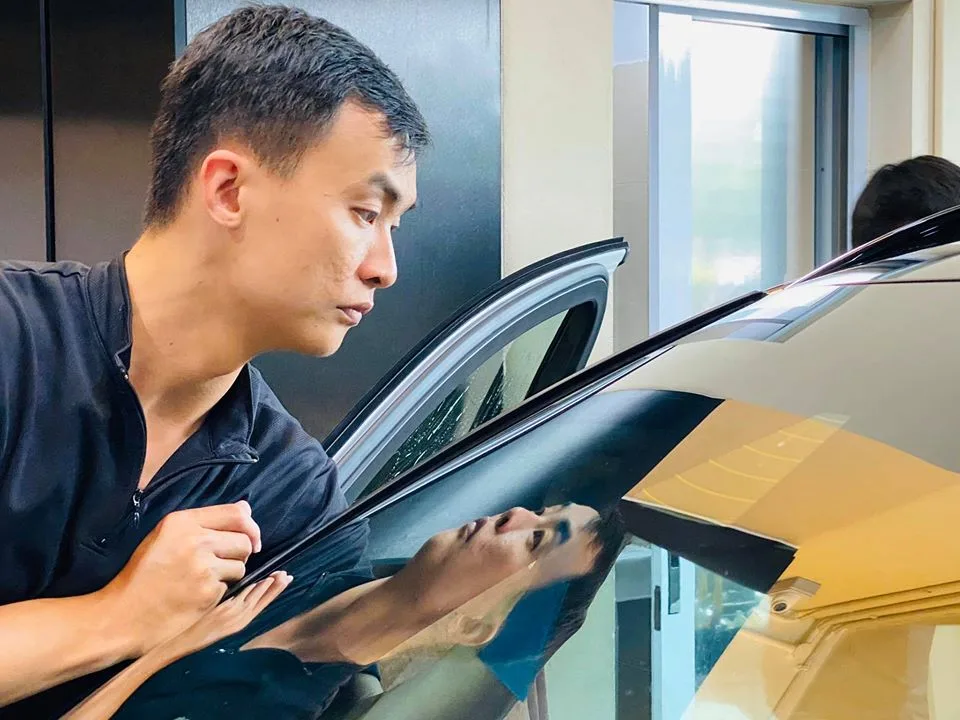 Installer fitting window film to a white Volvo XC40 at Infratint Singapore