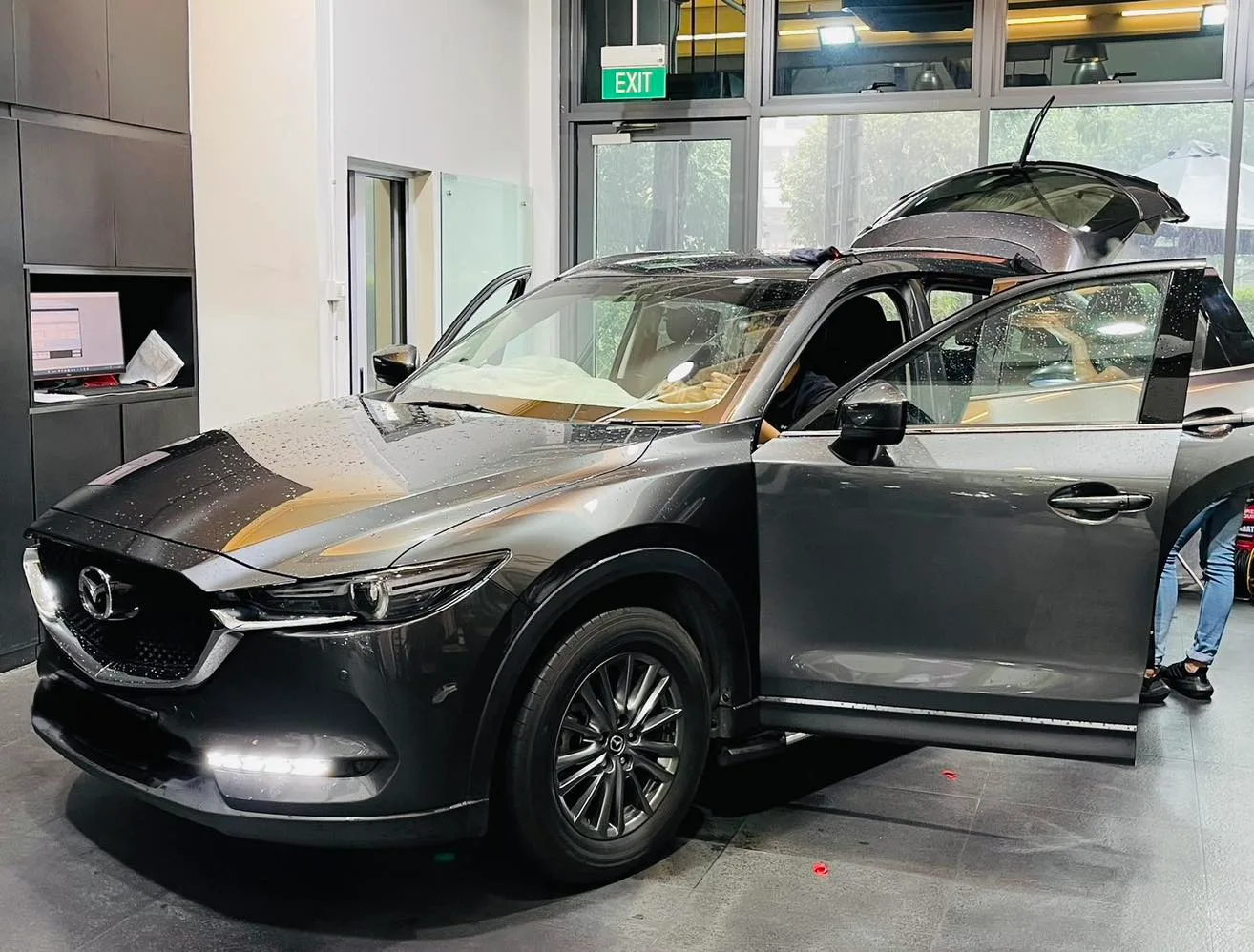 Grey Mazda CX-5 front three-quarter view during window tinting at Infratint Singapore