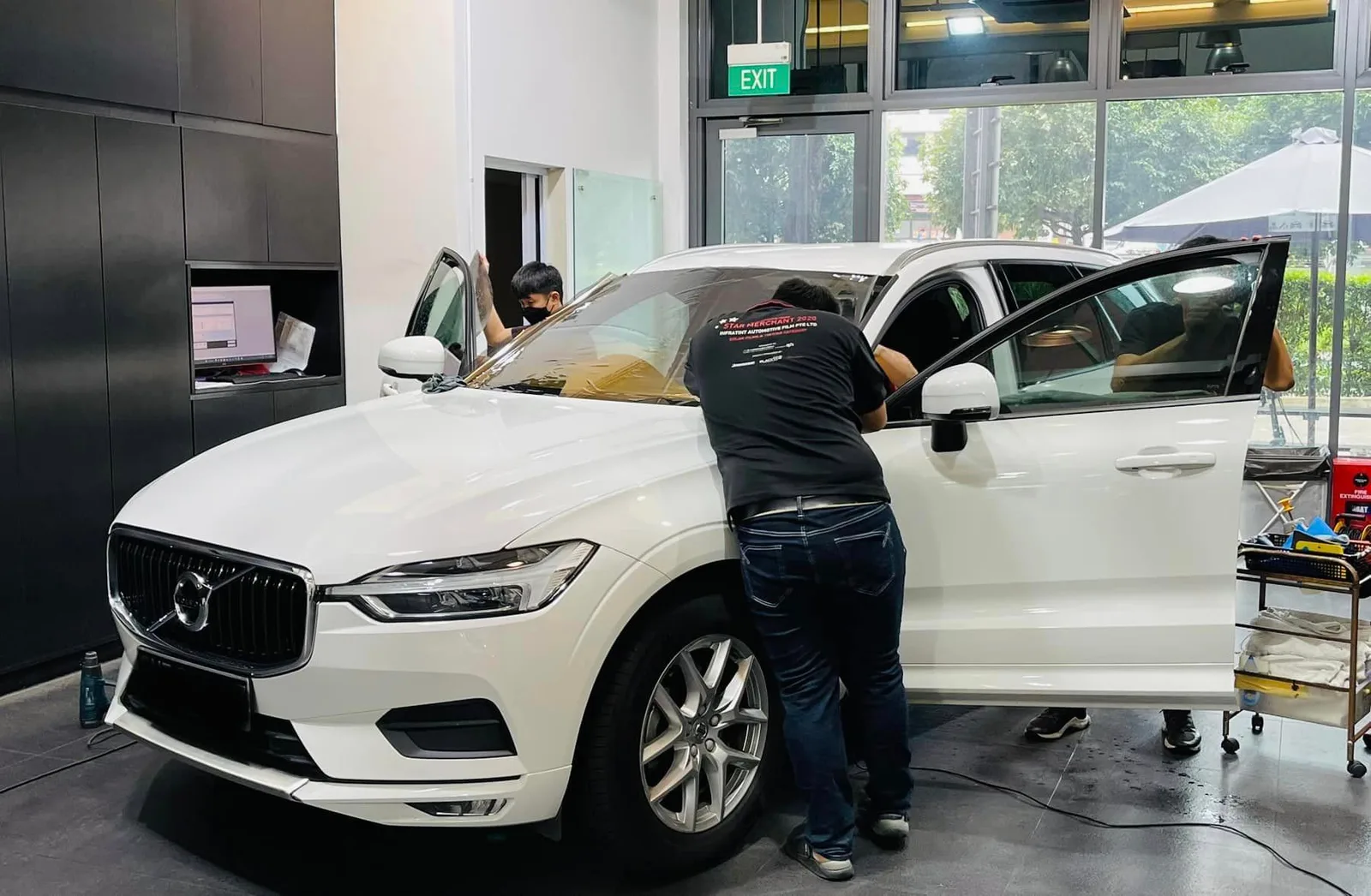 White Volvo XC60 front three-quarter view during window tinting at Infratint Singapore