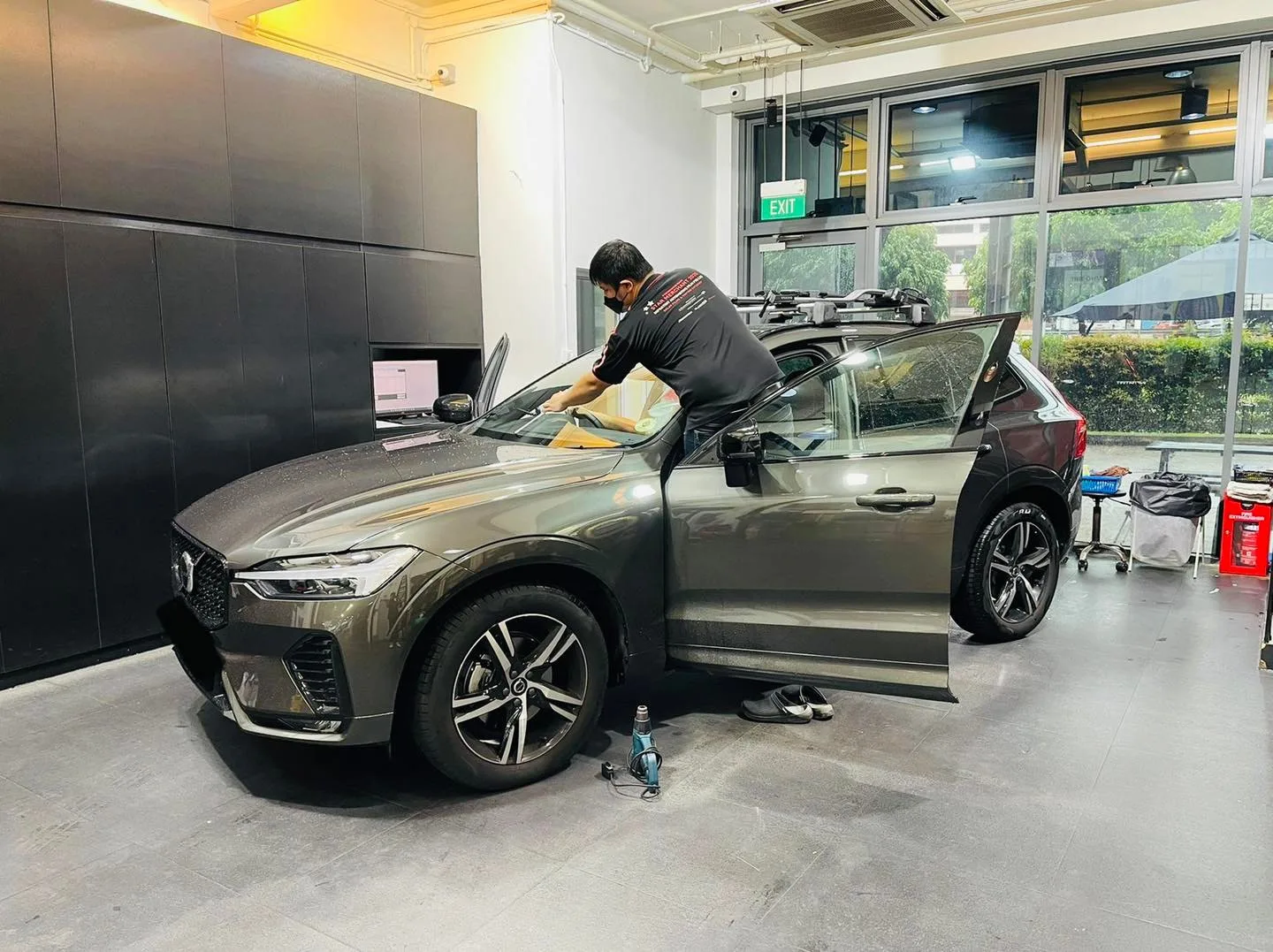 Technician applying window film to a bronze Volvo XC60 at Infratint Singapore
