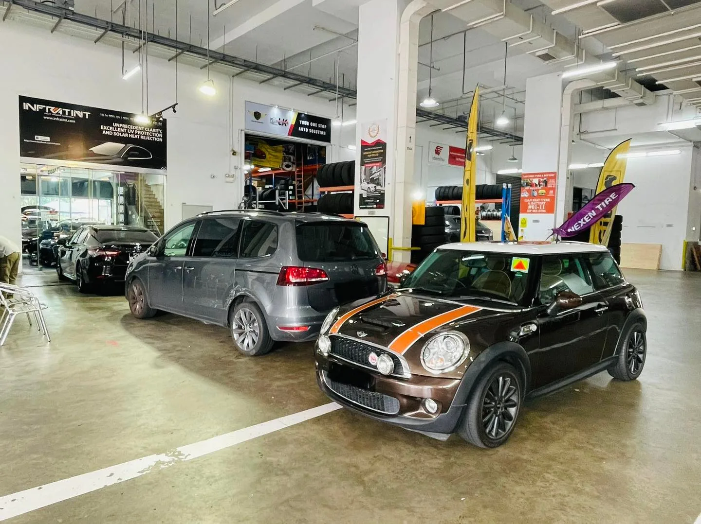 Grey Volkswagen Sharan MPV and striped black Mini Cooper S at Infratint Singapore