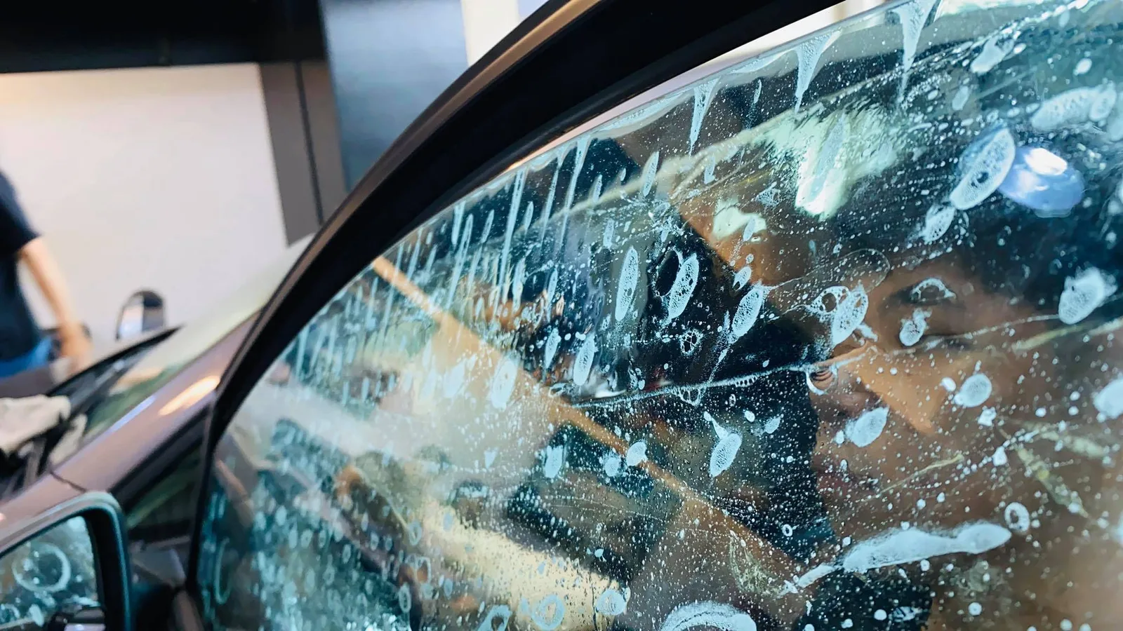 Window film being applied with slip solution on a Volkswagen Golf at Infratint Singapore