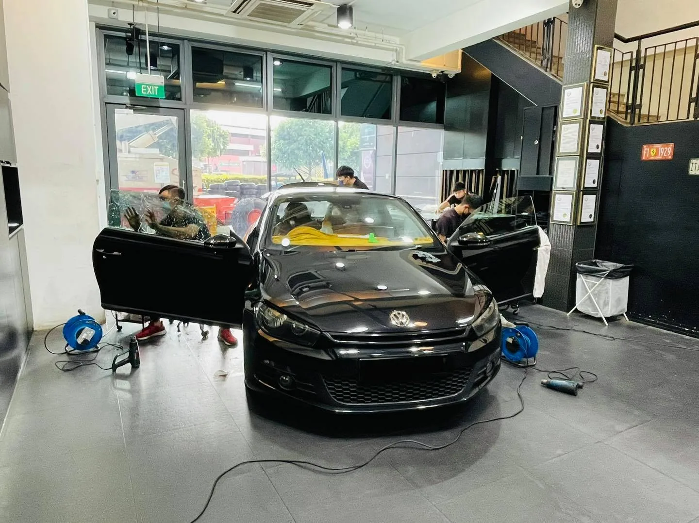Black Volkswagen Scirocco coupe with doors open during window tinting at Infratint Singapore