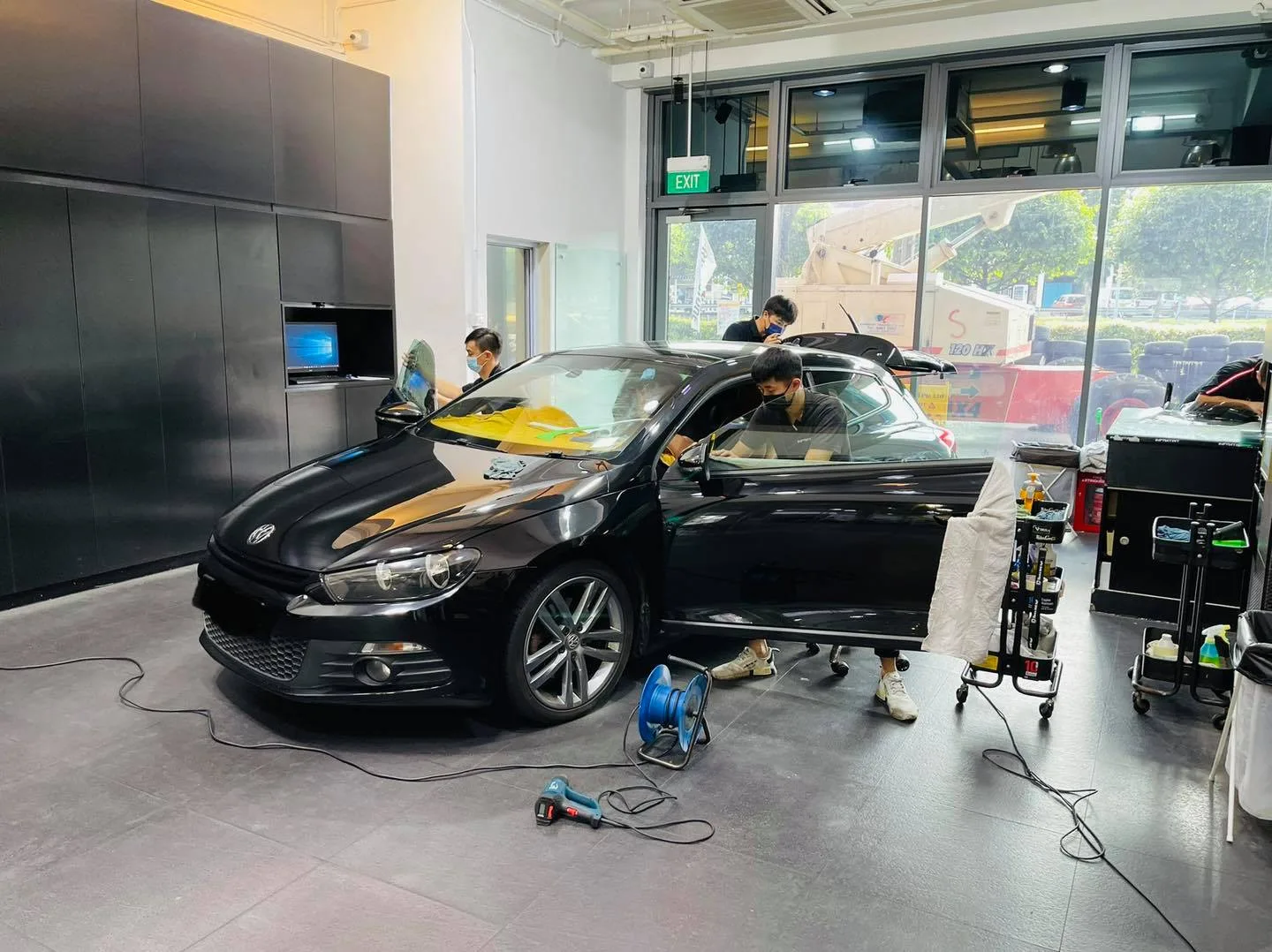 Black Volkswagen Scirocco side view during window film install at Infratint Singapore