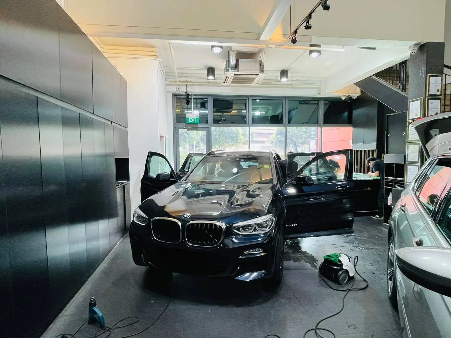 Black BMW SUV with doors open during window tinting at Infratint Singapore