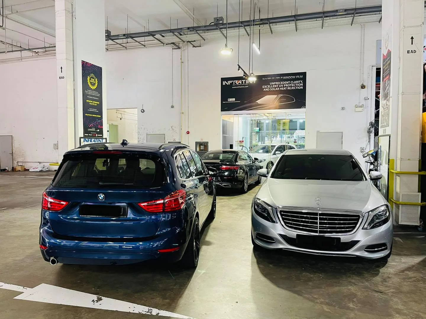 Blue BMW wagon and silver Mercedes-Benz sedan at the Infratint Singapore workshop