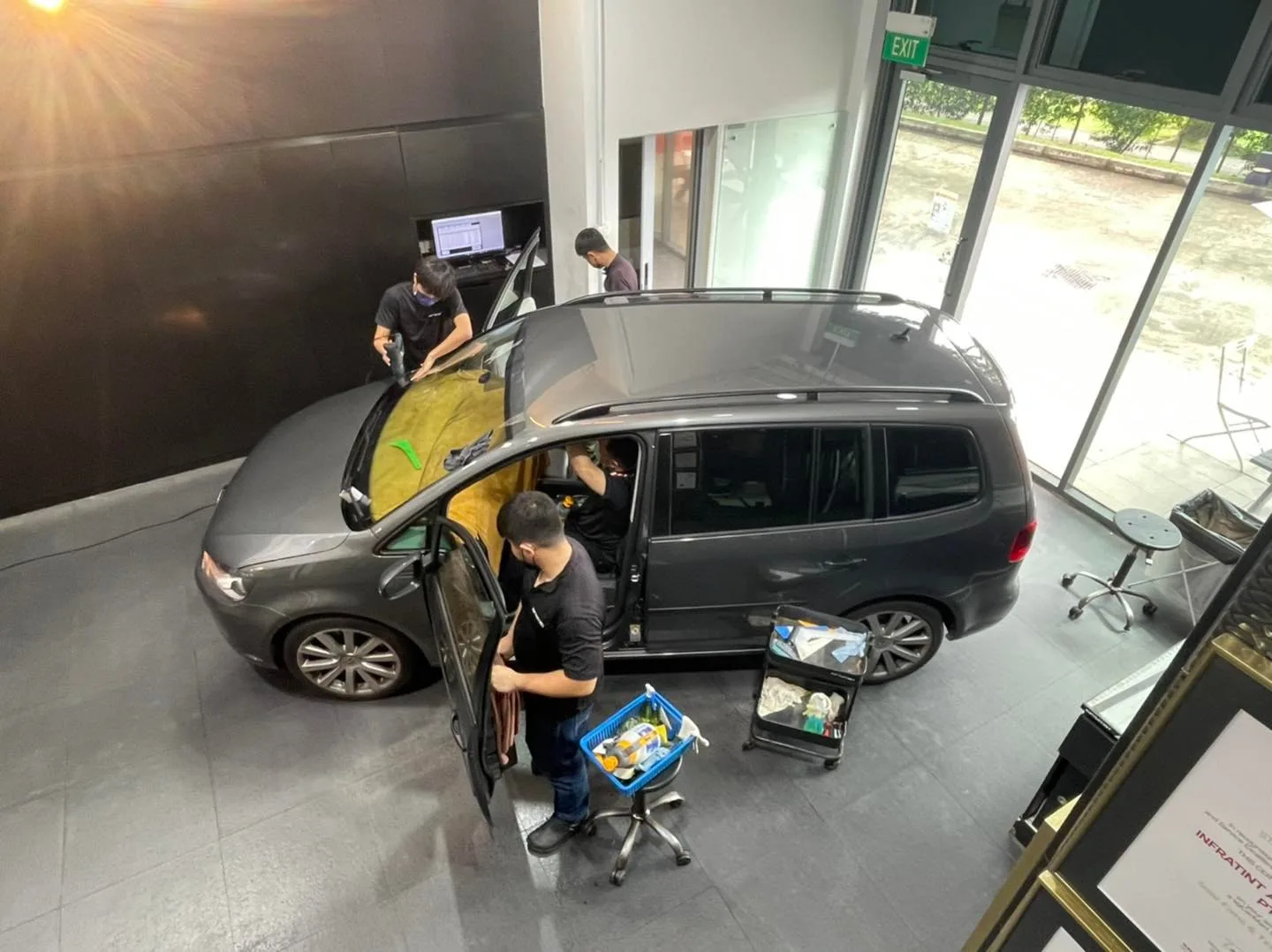Overhead view of a grey Volkswagen Touran with film on the windscreen at Infratint Singapore