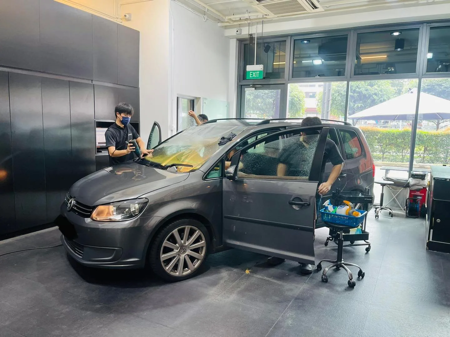 Grey Volkswagen Touran with doors open during window film install at Infratint Singapore