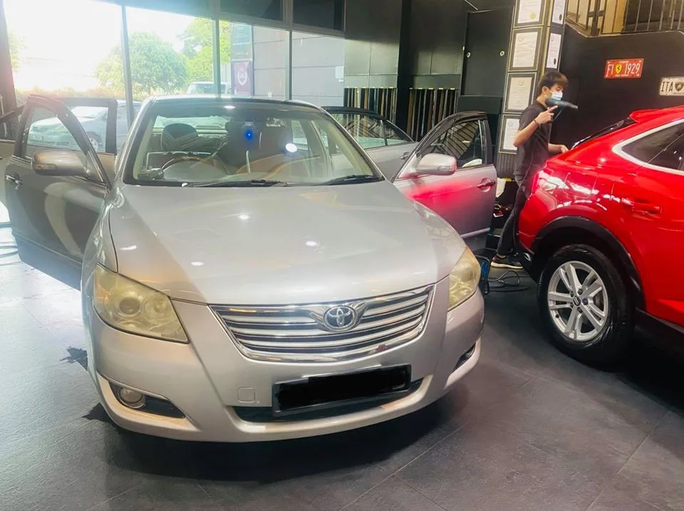Silver Toyota Camry and red Honda SUV during window tinting at Infratint Singapore
