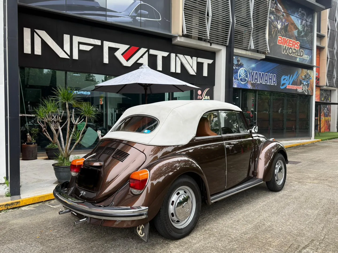 Brown Volkswagen Beetle convertible rear three-quarter view with cream soft top at Infratint Singapore