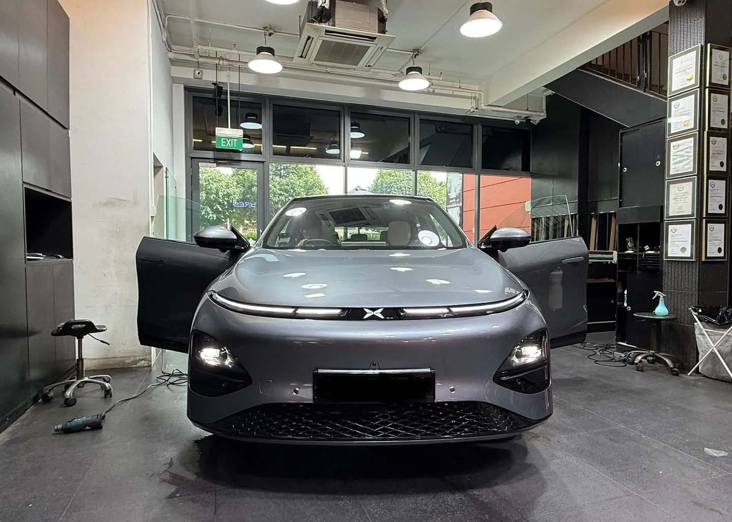 Grey XPENG G6 front view inside Infratint workshop with doors open